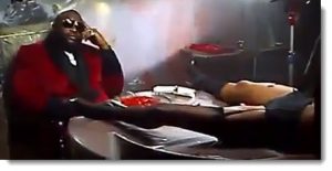 Rick Ross sits in view of a dead/drugged woman & a plate of raw meat 