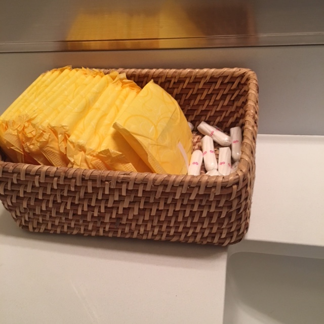 a wicker basket with menstrual supplies